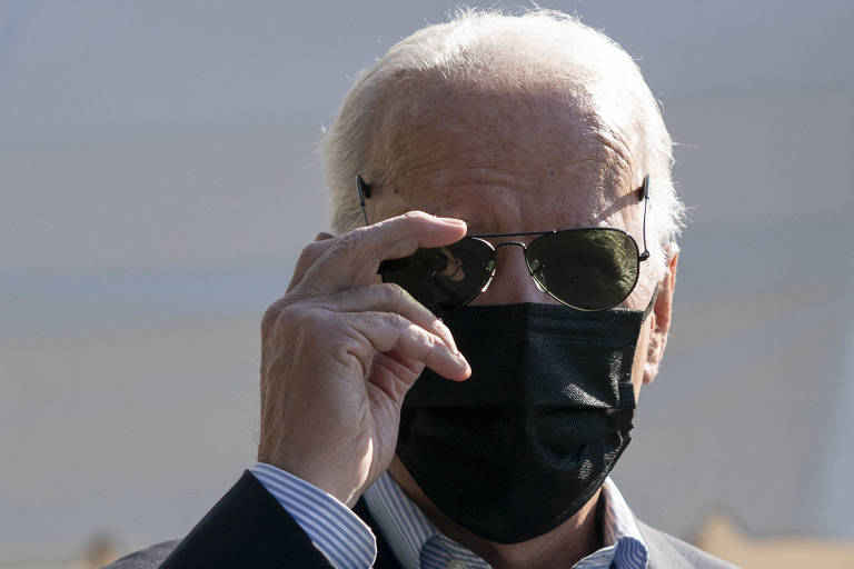 O presidente dos EUA, Joe Biden, usa óculos escuros e máscara de proteção contra o coronavírus