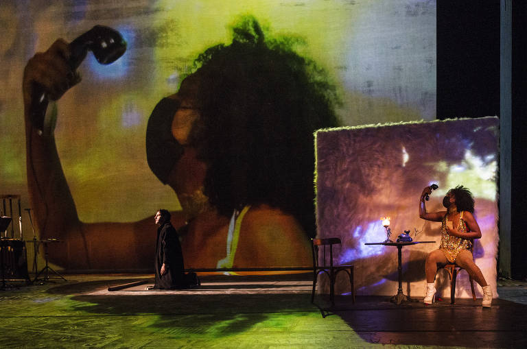 Além disso, ali e na tela no fundo do palco são projetadas imagens recentes e de arquivo de Buenos Aires e de São Paulo, além de cenas da própria ópera captadas em cena, como essa da atriz e prostituta Lua Negra