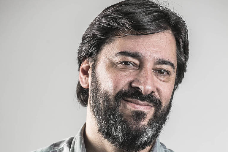 O jornalista Sandro Macedo sorri