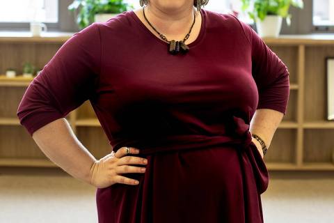 Mulher com vestido vermelho posa para foto de divulgação de aplicativo para pessoas gordas - Web Stories