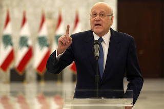 Lebanon's Prime Minister Najib Mikati gestures as he speaks to the press after meeting with Lebanon's President Michel Aoun at the presidential palace in Baabda