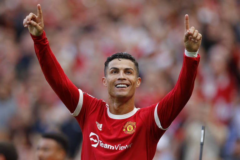 Ronaldo com uniforme vermelho, sorrindo e erguendo os braços