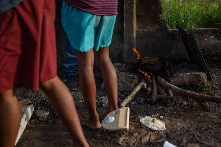Migrantes preparam refeições em ruas da cidade