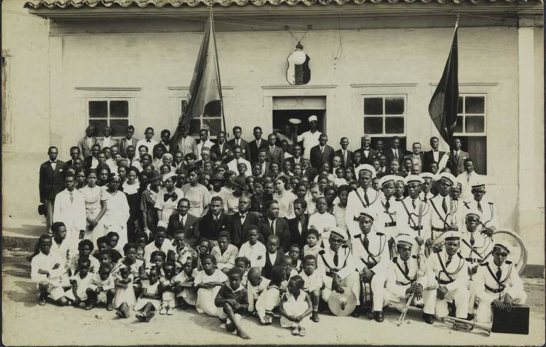 Um grupo de pessoas posa para foto em frente da sede da delegação da Frente Negra Brasileira