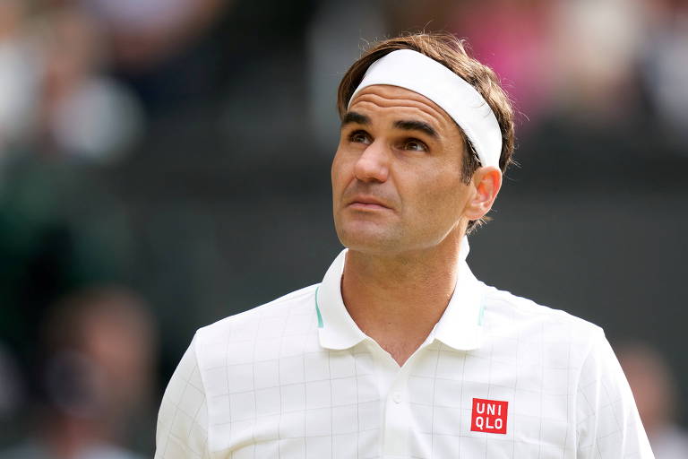 Federer, de camiseta e faixa brancas, olha para o alto durante partida