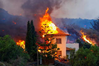 A house burns due to lava from the eruption of a volcano in Spain