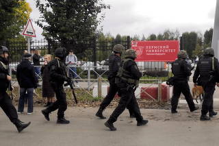 Law enforcement officers work near the scene of a shooting at university in Perm