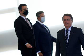 Brazil's President Bolsonaro walks next to President of the Senate Pacheco and Chamber of Deputies Speaker Arthur Lira before a ceremony in Brasilia