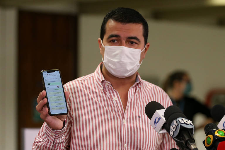 O deputado Luis Miranda (DEM-DF) conversa com jornalistas ao sair da CPI da Covid, após ser citado pelo depoente Luiz Paulo Dominguetti. Na foto ele mostra a conversa no WhatsApp em seu celular que comprovaria sua inocência.