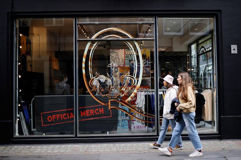 Pedestres passam pelas vitrines de uma nova loja que vende mercadorias oficiais do lendário grupo de rock britânico Queen no centro de Londres