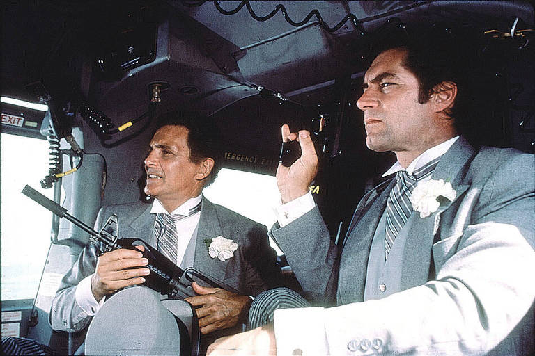 O ator aparece em um carro com uma arma em punho.