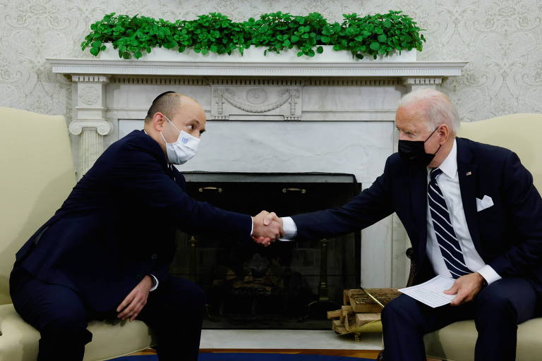 O presidente dos EUA, Joe Biden, e o primeiro-ministro de Israel, Naftali Bennett, apertam as mãos durante uma reunião no Salão Oval da Casa Branca, em Washington