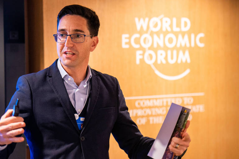 François Bonnici, homem branco, de óculos, fala em um painel com um backdrop escrito Fórum Econômico Mundial ao fundo