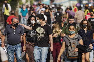 Uso de Mascara (ou nao) na Pandemia: Pedestres caminham na av Paulista com e sem mascara