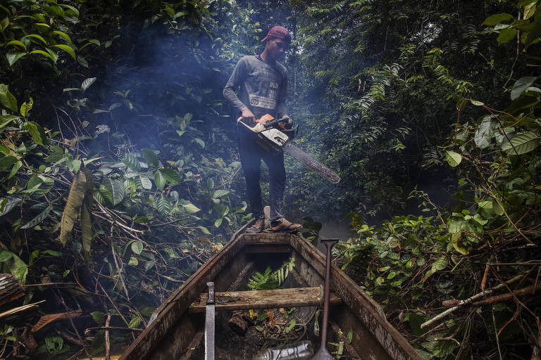Jasson Oliveira do Nascimento, morador da Reserva Extrativista Arapixi, no Amazonas, com serra elétrica na mão