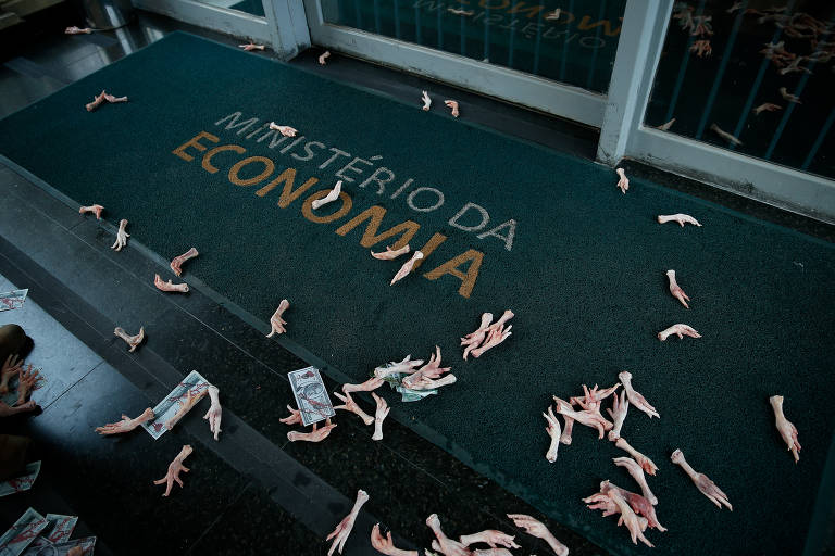 Os manifestantes jogaram pés de frango na entrada principal do Ministério, em protesto contra a inflação da comida. Relatos de brasileiros comendo pés de galinha, ossos e mudando os hábitos alimentares diante da inflação se tornaram frequentes durante a crise de Covid
