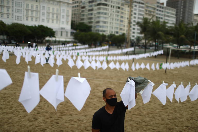 Membro da ONG Rio de Paz põe lenços brancos em homenagem aos 600 mil mortos pelo Covid