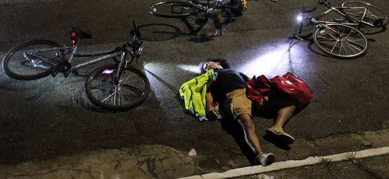 um homem deitado no chão com bicicletas caídas ao redor 