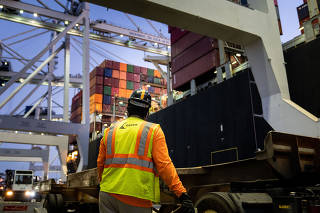 A worker waits for a crane to start moving containers from ship to shore at the Port of Savannah, which is running out of places to put a pileup of nearly 80,000 of them, in Savannah, Ga., Sept. 30, 2021. (Erin Schaff/The New York Times)
