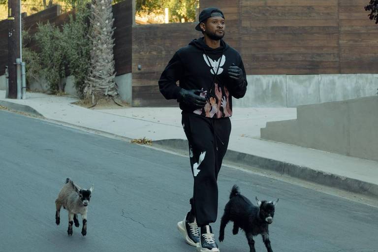 Homem vestido de preto correndo pela rua ao lado de duas cabras filhotes