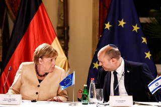 German Chancellor Angela Merkel and Israeli Prime Minister Naftali Bennett chat during a roundtable discussion with Israeli entrepreneurs in Jerusalem