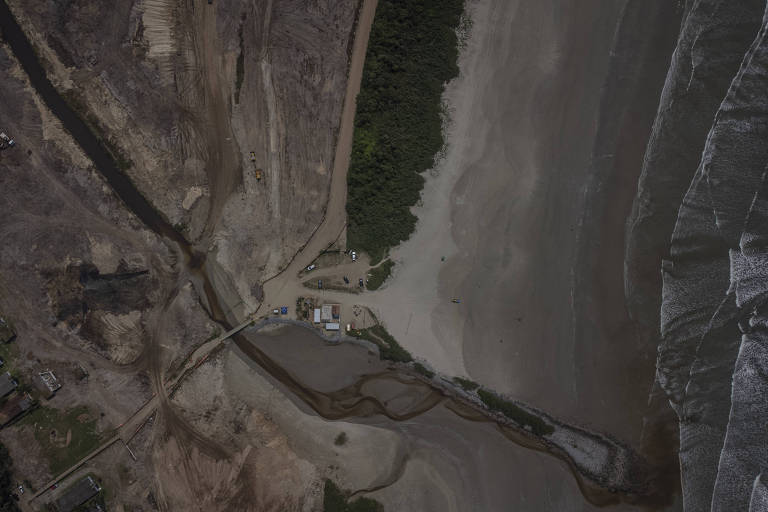 imagem aérea: do lado direito, ondas do mar; ao centro, pequena área com vegetação conservada; à esquerda da imagem, área com terra recentemente desmatada