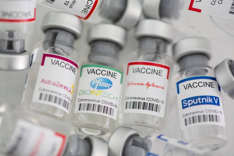 Imagem mostra frascos dos imunizantes contra Covid da AstraZeneca, Pfizer, Janssen e Sputnik V, um ao lado do outro, deitados, com os rótulos para cima 