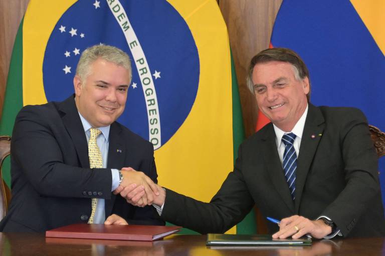 À esquerda, Ivan Duque, presidente da Colômbia, aperta a mão de Bolsonaro