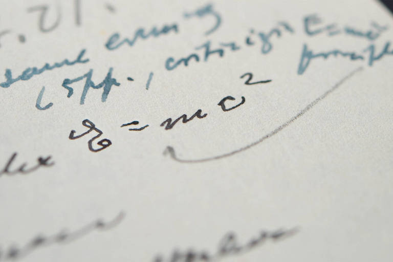 Palavras escritas em uma página branca; entre as palavras há a famosa fórmula de Einstein