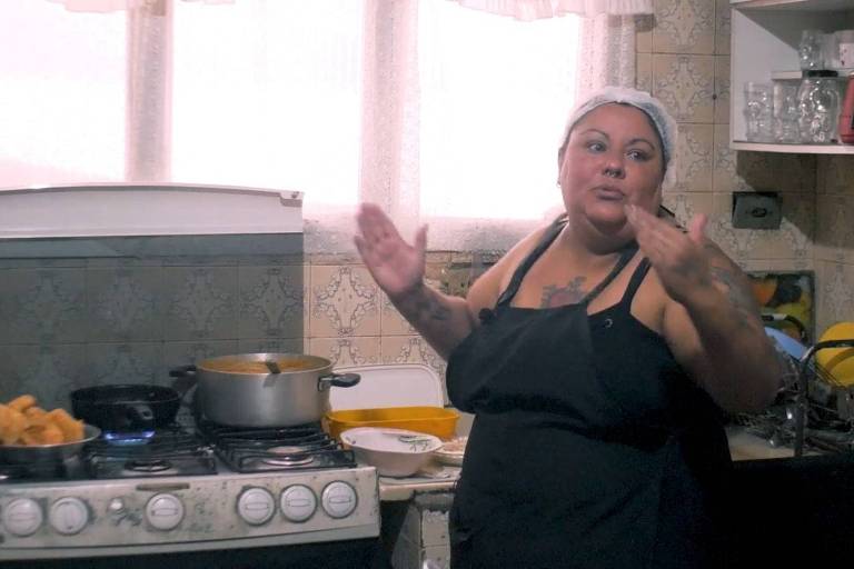 mulher cozinheira está ao lado do fogão gesticulando