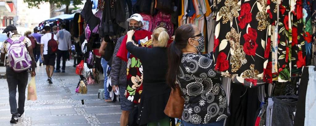 Consumidores observam produtos à venda em rua de comércio popular no centro de São Paulo