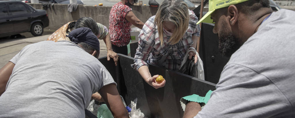 Pessoas selecionam restos alimentos no descarte do Mercadão Municipal, centro de SP