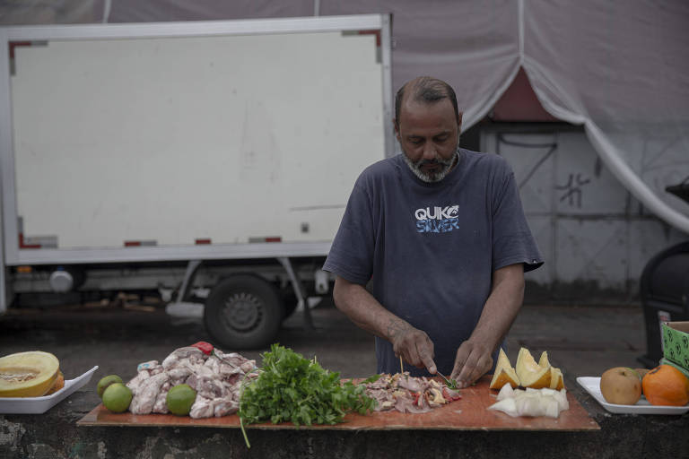Lênin Oliveira prepara alimentos que pegou do Mercadão Municipal de São Paulo