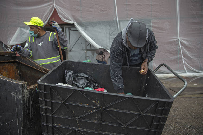 Famílias em busca de alimentos a serem descartados no Mercado Municipal 
