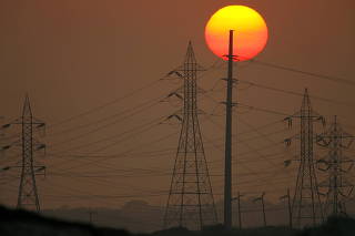 FILE PHOTO: Sun sets behind power lines in California
