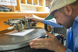 Moose Adamson sets up a lathe to cut records individually at Joyful Noise in Indianapolis, Oct. 5, 2021. (AJ Mast/The New York Times)