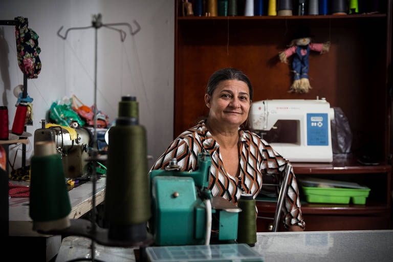 Rosely Mendes Couto, enfermeira que hoje trabalha com costura criativa, sentada ao lado da máquina de costura