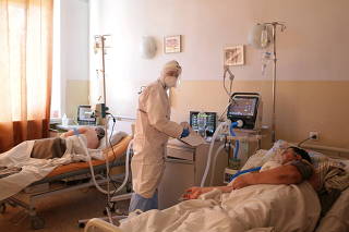 A medical specialist tends to a COVID-19 patient at a hospital in Kherson