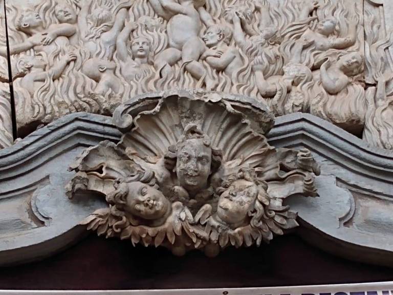 Obra atribuída a Aleijadinho em que aparecem três cabeças de anjos na fachada da igreja de Bom Jesus de Matosinhos das Cabeças, em Ouro Preto.