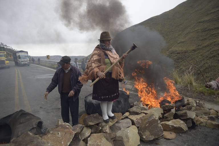 Mulher indígena sobre uma barricada, durante o bloqueio de uma estrada que liga a costa as áreas montanhosas, perto de Zumbahua, no Equador, em protesto contra o governo de Guillermo Lasso