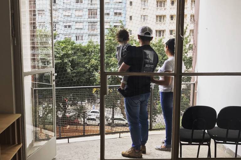 Mariana da Silva Moura com o marido e o filho no apartamento reformado pelo Fundo Fundo