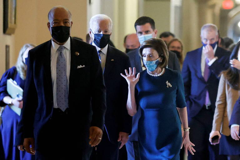 Ao lado da presidente da Câmara dos Representantes, Nancy Pelosi, o presidente Joe Biden caminha no Capitólio, em Washington