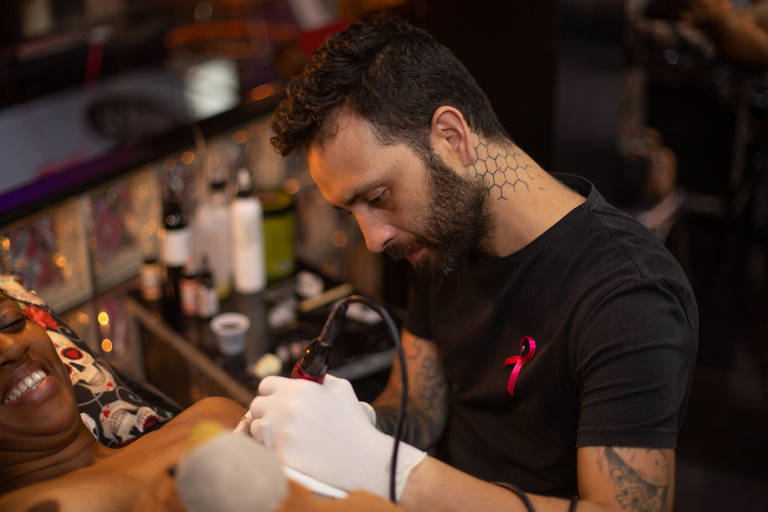 O tatuador Yurgan Barret trabalha em recontrução de mamilo e aréola durante o evento Y Rosa, no Rio