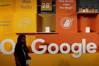 Mulher caminha pelo logotipo do Google durante um evento em Nova Deli, Índia