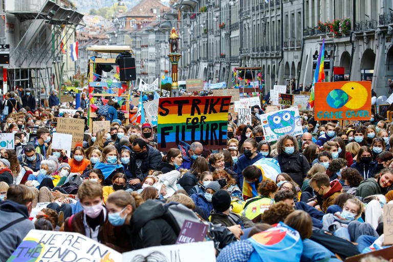 Pessoas muito próximas umas às outras protestam no meio da rua; em uma placa colorida no meio da multidão é possível ler "Greve pelo Futuro"