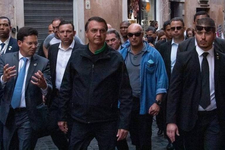 Bolsonaro caminha em rua de roma, sem máscara, cercado por seguranças