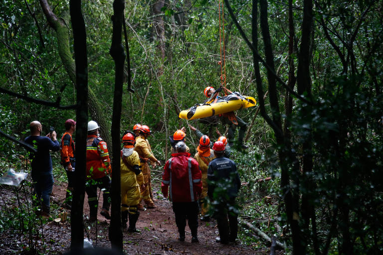 Corpo de vitima é levantado por corda de um helicóptero entrada da gruta em Altinópolis (SP)