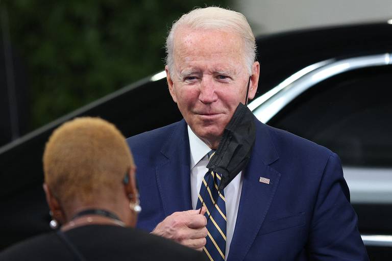 O presidente dos Estados Unidos, Joe Biden, retira máscara ao chegar à conferência sobre mudanças climáticas, em Glasgow, Escócia
