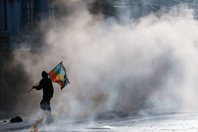 Manifestante com bandeira mapuche durante protesto contra o governo chileno em Valparaíso