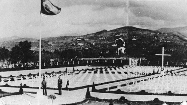 foto em preto e branco de monumento em meio a montanhas com bandeira do brasil hasteada em mastro